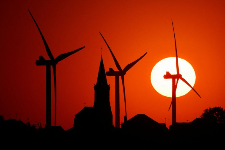 Photo d'archives d'éoliennes et d'une église au coucher du soleil à Béthencourt