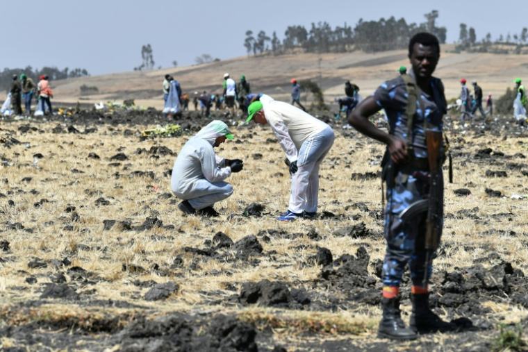 Des experts médico-légaux sur le site du crash de l'avion Boeing 737 MAX exploité par Ethiopian Airlines, dans le village de Hama Quntushele, le 13 mars 2019 en Ethiopie ( AFP / TONY KARUMBA )