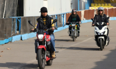 La monitrice Maryam Ghelich (g) guide les élèves Elham (c) et Mona sur leurs scooters dans un centre d'entraînement du nord de Téhéran, le 7 décembre 2025 en Iran ( AFP / ATTA KENARE )