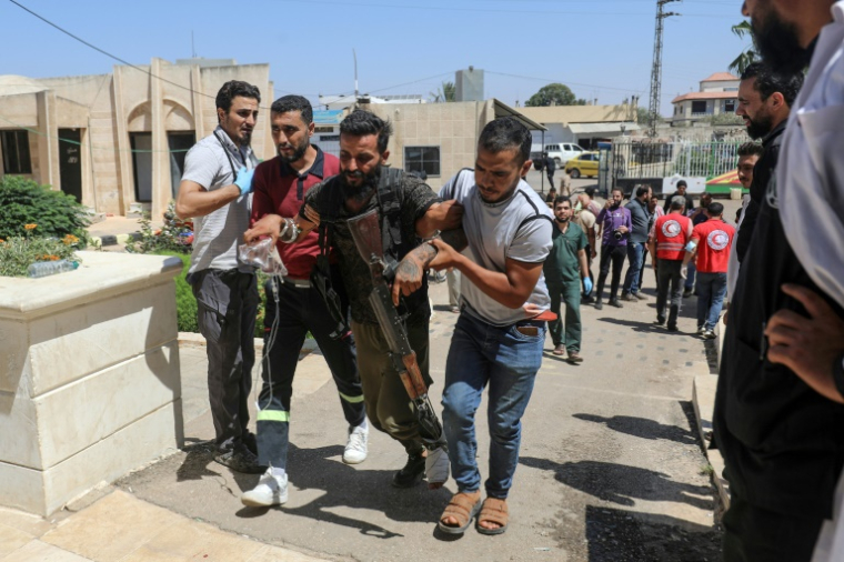 Un combattant bédouin syrien blessé lors d'affrontements avec des combattants druzes près de Soueida dans le sud de la Syrie, est transporté dans un hôpital d'Izra, dans la province proche de Deraa, le 19 juillet 2025 ( AFP / Abdulaziz KETAZ )