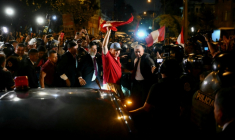 Rafael Lopez Aliaga (au centre), candidat à la présidence du Pérou, agite le drapeau national péruvien pendant un rassemblement devant le siège du Jury national des élections (JNE) à Lima, le 14 avril 2026 ( AFP / Luis ROBAYO )