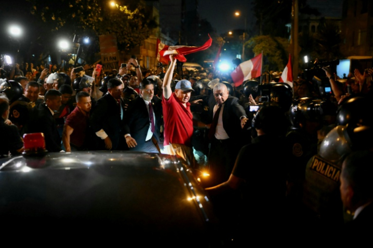 Rafael Lopez Aliaga (au centre), candidat à la présidence du Pérou, agite le drapeau national péruvien pendant un rassemblement devant le siège du Jury national des élections (JNE) à Lima, le 14 avril 2026 ( AFP / Luis ROBAYO )