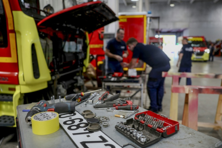 Des mécaniciens réparent un camion de pompiers endommagé par les incendies de forêt de l'été, dans l'atelier de logistique et de maintenance du SDIS 33 à Bordeaux, le 16 septembre 2026 en Gironde ( AFP / ROMAIN PERROCHEAU )