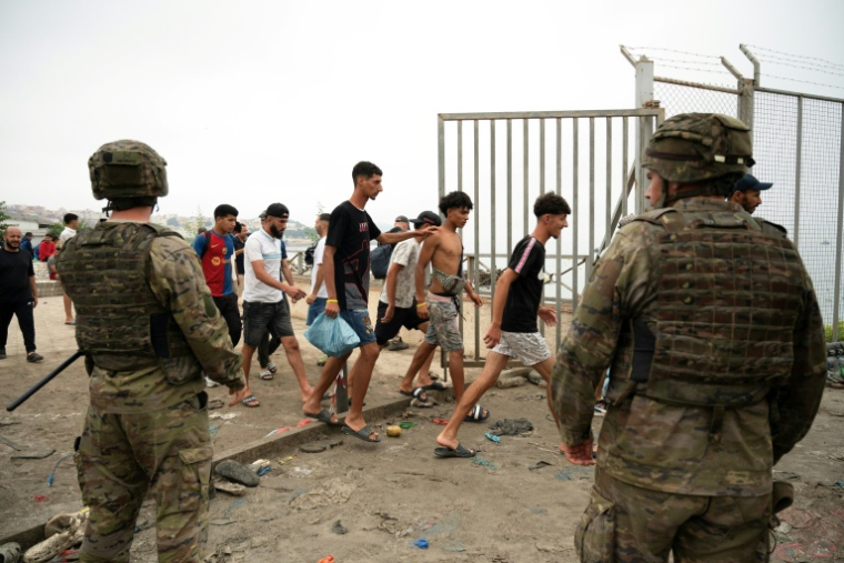 Soldiers watching as migrants cross back into Morocco ( AFP / JORGE GUERRERO )