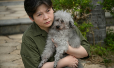 Jacky Lee, avec son caniche Jason, sauvé par les pompiers au milieu du pire incendie de Hong Kong, le 1er décembre 2025 ( AFP / Peter PARKS )