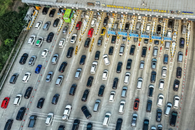 Vue aérienne d'automobilistes bloqués dans un embouteillage au péage d'une autoroute, alors que des dizaines de millions d'habitants regagnent leurs villes natales pour la fête de l'Aïdle 17 mars 2026à Cikampek, en Indonésie ( AFP / BAY ISMOYO )