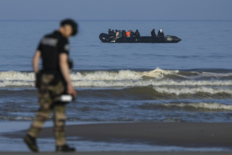 Un gendarme sur la plage d'Equihen (Pas-de-Calais), devant une embarcation transportant des migrants, le 30 juin 2025 ( AFP / Sameer Al-DOUMY )