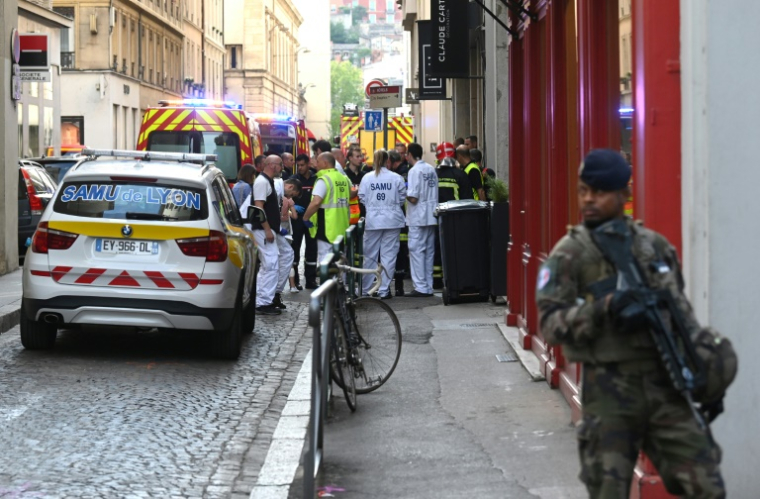 Des membres des services de secours rassemblés sur les lieux d'un attentat à la bombe le 24 mai 2019 dans le centre de Lyon ( AFP / PHILIPPE DESMAZES )