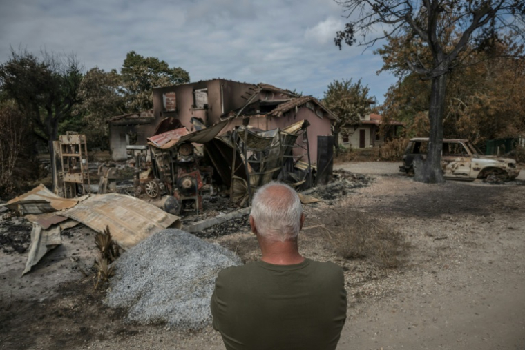 Un habitant devant les ruines de sa maison ravagée par les flammes dans la commune de Le Porge, le 31 juillet 2026  ( AFP / Ed JONES )