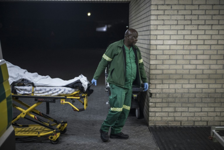 L'ambulancier Mawethu Ntintini transporte un blessé à l'hôpital de Mitchells Plain, près du Cap, le 15 avril 2025 en Afrique du Sud ( AFP / MARCO LONGARI )