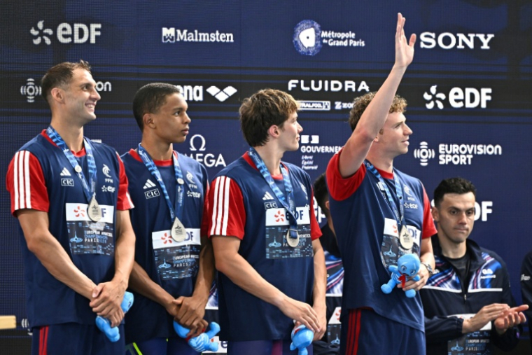 L'équipe de France, lancée par Léon Marchand (bras levé) et avec Roman Fuchs, Sauveur Cristofini et Pierre Largeron, a décroché la médaille d'argent du 4x200 m aux Europes de natation au Centre aquatique olympique de Saint-Denis, le 10 août 2026. ( AFP / JULIEN DE ROSA )