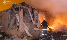 Photo diffusée le 26 février 2026 par le Service ukrainien des situations d'urgence montrant un pompier éteignant un incendie dans une maison endommagée après une attaque russe à Kharkiv ( Service ukrainien des situations d'urgence / Handout )