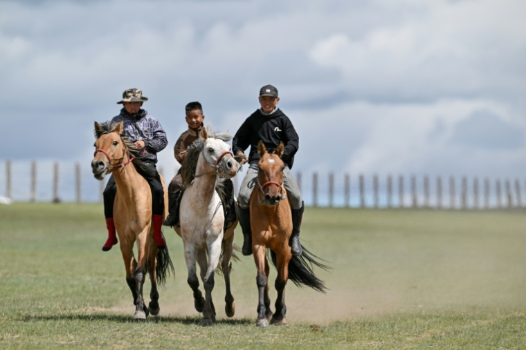 Hurts Gantumur (c), 6 ans, monte à cheval avec d'autres garçons avant le festival Naadam, le 23 juin 2026 à la périphérie d'Oulan-Bator, en Mongolie ( AFP / Adek BERRY )