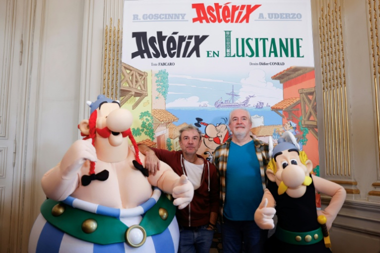 Les auteurs de la série Astérix et Obélix, Fabcaro (au centre à g.) et Didier Conrad (au centre à d.), posent entourés de personnes déguisées en Astérix (d) et Obélix (g), à l'ambassade du Portugal à Paris, le 13 octobre 2025 ( AFP / Ian LANGSDON )