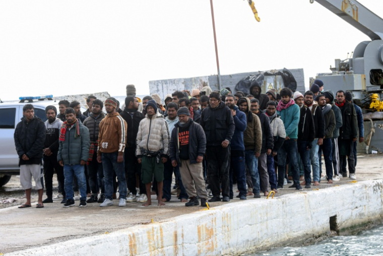 Des migrants au port de Kaloi Limenes, au sud d'Héraklion, en Crète, après avoir été secourus par les garde-côtes grecs, le 21 février 2026 ( AFP / Costas METAXAKIS )
