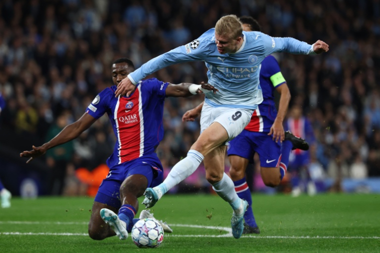 Le buteur des Citizens Erling Haaland s'infiltre dans la surface parisienne avant d'être taclé par le roc du PSG Willian Pacho, le 14 octobre 2026  ( AFP / FRANCK FIFE )