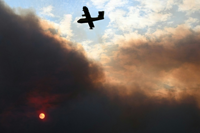 Un Canadair de la sécurité civile en vol lors d'un incendie de forêt à Fontjoncouse, dans l'Aude, le 6 août 2025 ( AFP / Lionel BONAVENTURE )