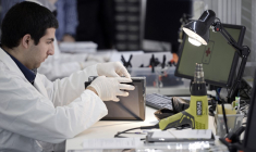 Un technicien répare une tablette  dans l'entreprise "Allo Smartphone" à Paris, le 7 novembre 2014. ( AFP / STEPHANE DE SAKUTIN )