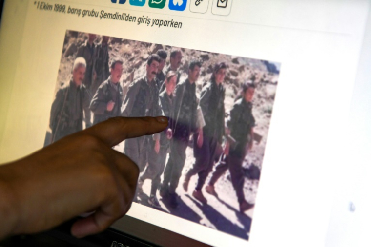 Yüksel Genç, ancienne combattante du Parti des travailleurs du Kurdistan (PKK), montre des vieilles photos sur un ordinateur lors d'un entretien avec l'AFP, le 21 mai 2025 à Diyarbakir, en Turqui ( AFP / Ilyas AKENGIN )