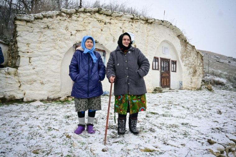 Maria Ardeleanu g) et une amie devant une maison-musée "basca" au village de Rogojeni, le 4 janvier 2026 en Moldavie ( AFP / Daniel MIHAILESCU )