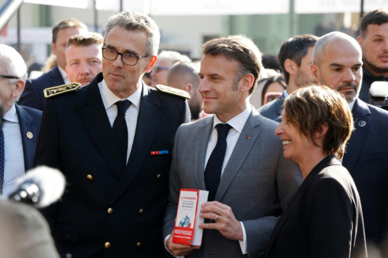 Marc Guillaume, alors préfet de la région Ile-de-France, pose avec le président Emmanuel Macron qui tient un exemplaire du livre sur la Constitution co-écrit par M. Guillaume, le 11 avril 2025 au festival du livre de Paris ( POOL / Ludovic MARIN )