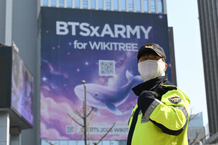 Un policier en faction sur la place de Séoul devant accueillir le concert de BTS, le 21 mars 2026 ( AFP / Jung Yeon-je )