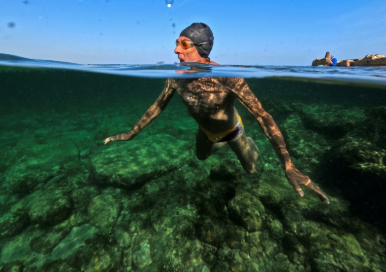 Lazaro Diaz, un retraité cubain de 75 ans, membre du club "Jeunesse accumulée", nage dans une piscine d'eau de mer à La Havane, le 17 mai 2025 ( AFP / YAMIL LAGE )