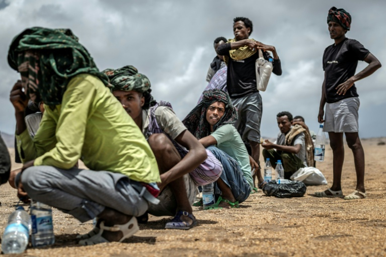 Des migrants éthiopiens se reposent, le 12 avril 2026, dans une zone désertique de Djibouti après avoir reçu de l'aide de la part de l'Organisation internationale pour les Migrations (OIM) ( AFP / Luis TATO )