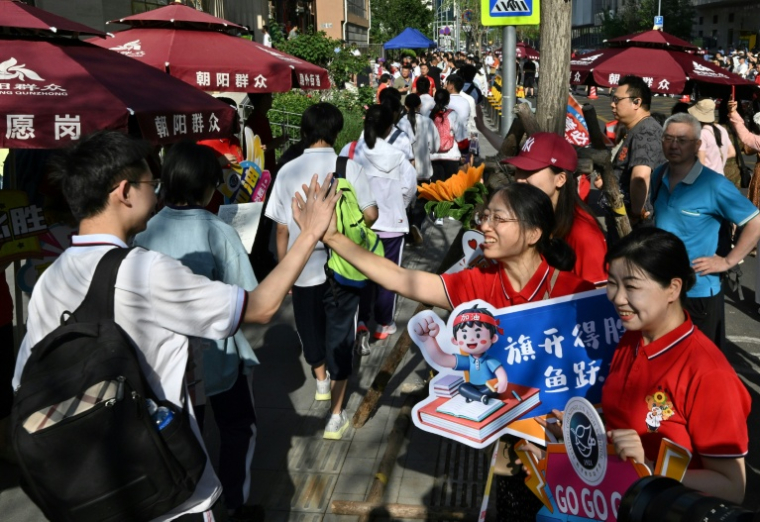 Professeurs et membres du personnel scolaire viennent apporter leur soutien aux lycéens qui passent le "Gaokao" à Pékin, le 7 juin 2025 ( AFP / Adek BERRY )
