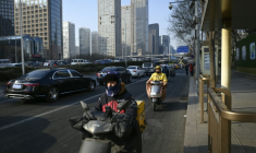 Des livreurs de repas conduisent des scooters électriques à Pékin, le 16 janvier 2024 ( AFP / WANG Zhao )