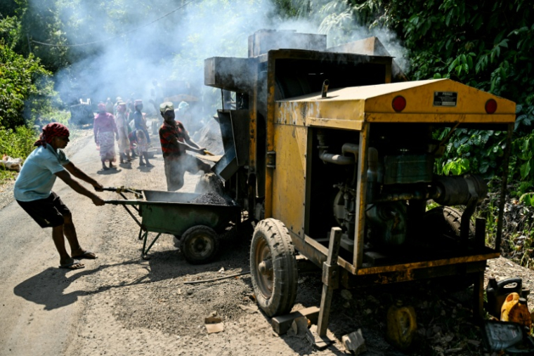 Des ouvriers attelés à la construction d'une route traversant des terres forestières dans le cadre d'un projet de grands travaux, le 26 mars 2026 près de Campbell Bay, sur l'île de Grande Nicobar, dans l'archipel indien des Andaman-et-Nicobar  ( AFP / R. Satish BABU )
