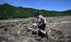 Une femme passe devant une zone endommagée par les pluies dans le district de Huairou, à la périphérie de Pékin, le 30 juillet 2025 ( AFP / Pedro Pardo )