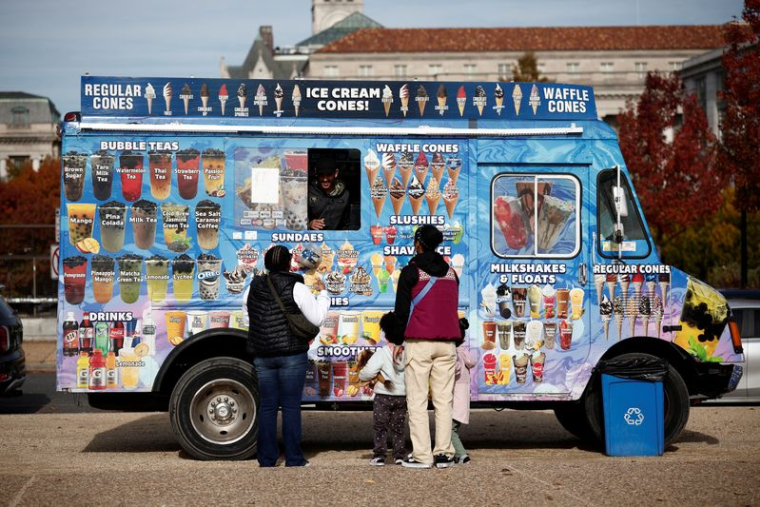 Des clients commandent des friandises glacées à un camion de glaces sur le National Mall à Washington, D.C.