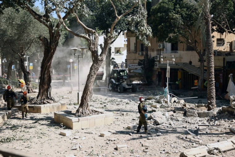 Un secouriste israélien se tient au milieu des décombres, devant un bâtiment touché lors d’une frappe iranienne dans la ville portuaire de Haïfa, le 22 juin 2025 ( AFP / Fadel SENNA )
