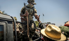 Un militaire malgache salue du poing un civil alors que des manifestants se rassemblent pour un meeting de la société civile devant l'hôtel de ville d'Antananarivo, le 13 octobre 2025 ( AFP / Luis TATO )