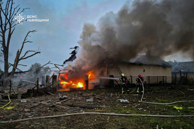 Photo prise et diffusée par les services d'urgence ukrainiens, le 5 octobre 2025, luttant contre un incendie sur le site d'une attaque aérienne russe dans la région de Lviv, en Ukraine ( Services d'urgence ukrainiens / Handout )