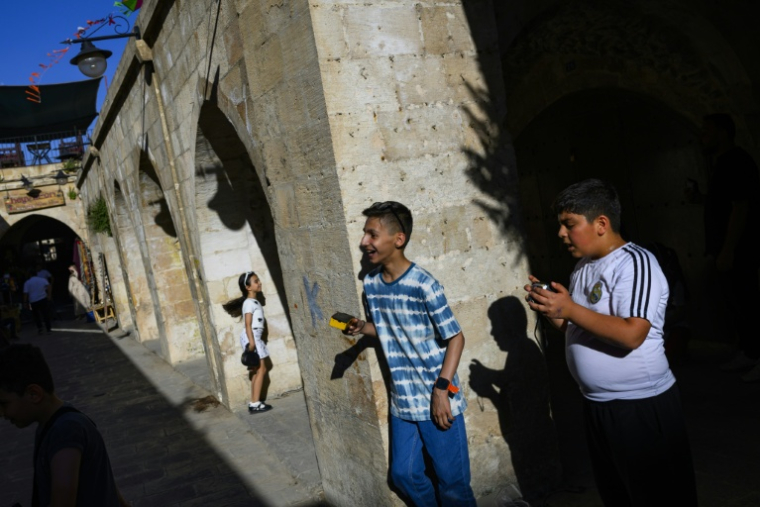 Des enfants prennent des photos leurs appareils argentiques lors d'un atelier organisé dans le cadre du projet "Fotohane Darkroom" à Mardin, dans le sud-est de la Turquie, le 14 juin 2026 ( AFP / Yasin AKGUL )