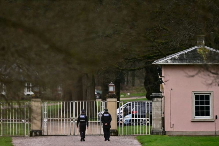 Des policiers devant l'entrée de la propriété Royal Lodge, ancienne résidence du prince Andrew, le 20 février 2026 à Windsor, à l'ouest de Londres, où des perquisitions sont effectuées ( AFP / Ben STANSALL )