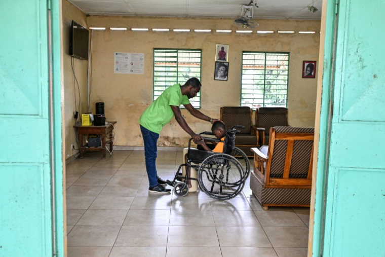Célestin N'Goran, directeur du d'un établissement qui assure une prise en charge de déficiants  intellectuels, s'occupe d'un patient à Bouaké, en Côte d'Ivoire, le 17 septembre 2026 ( AFP / Issouf SANOGO )
