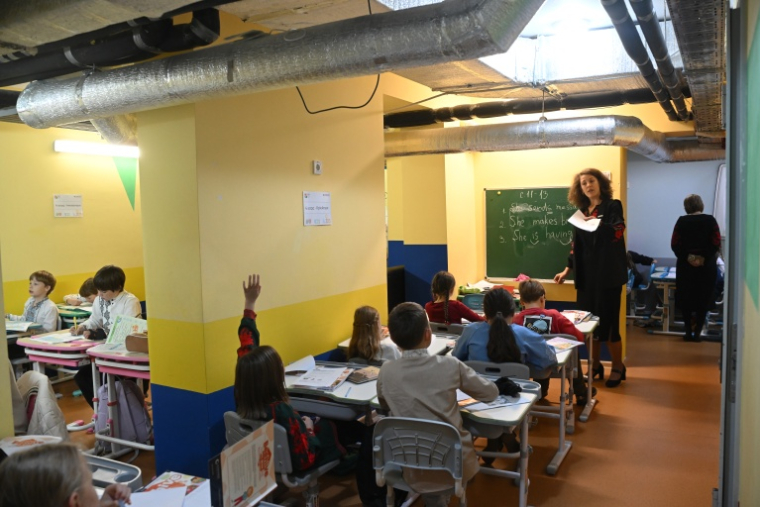 Des écoliers ont classe dans un abri installé au sous-sol de leur école primaire pendant une alerte aérienne en banlieue de Kiev, le 20 octobre 2026 ( AFP / Sergei SUPINSKY )