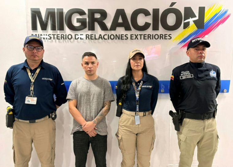 Photo fournie par le service de presse de l'autorité migratoire colombienne, montrant Angel Aguilar (2e à partir de la gauche) membre du gang Los Lobos, après son arrestation, à Bogota le 18 mars 2026 ( Colombian Migration Office / Handout )