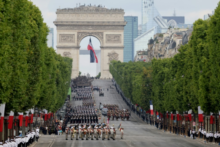 Le président français Emmanuel Macron et le chef d'état-major des armées de la France Thierry Burkhard passent en revue les troupes lors du défilé militaire annuel de la fête nationale sur l'avenue des Champs-Élysées à Paris, le 14 juillet 2025 ( AFP / Ludovic MARIN )