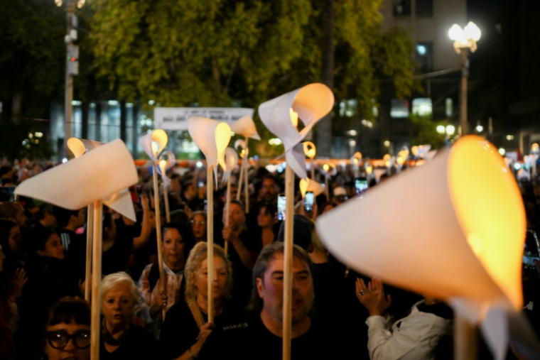 Des gens brandissant des foulards blancs illuminés se sont rassemblées sur la Plaza de Mayo à Buenos Aires le 23 mars 2026 pour participer à une veillée, à la veille du 50e anniversaire du coup d'Etat militaire qui a marqué le début de la dictature militaire (1976-1983) ( AFP / Luis ROBAYO )