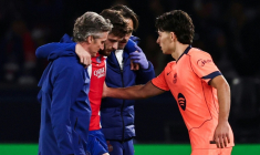 L'attaquant du PSG Khvicha Kvaratskhelia (c) quitte la pelouse après s'être blessé au genou droit lors du match contre le FC Barcelone, réconforté par Xavi Espart, le 20 octobre 2026 au Parc des Princes ( AFP / FRANCK FIFE )