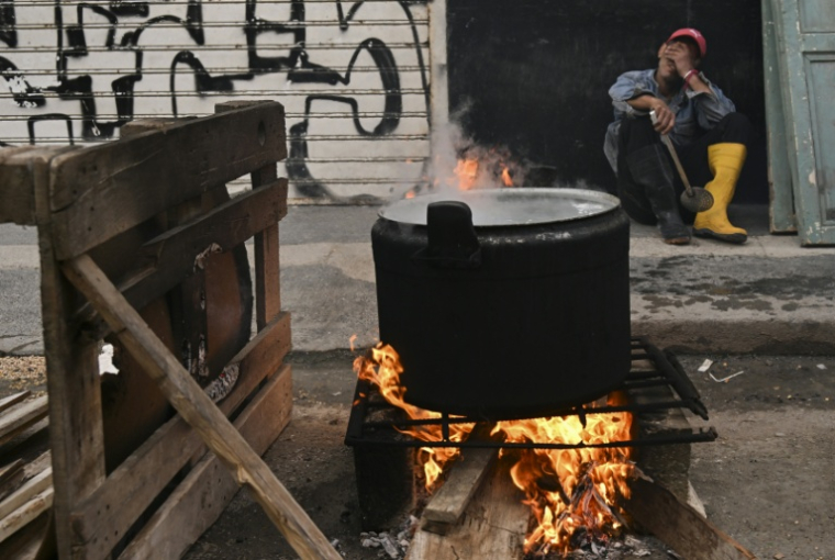 Un homme devant une marmite cuisant au feu de bois dans une rue de La Havane, le 23 février 2026 ( AFP / YAMIL LAGE )