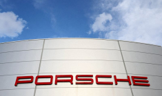 Un logo de Porsche est visible devant un concessionnaire Porsche à Bruxelles