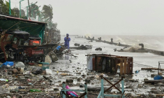 Un homme se tient à côté de débris près du bord de mer, le 22 septembre 2025 à Aparri aux Philippines ( AFP / John Dimain )