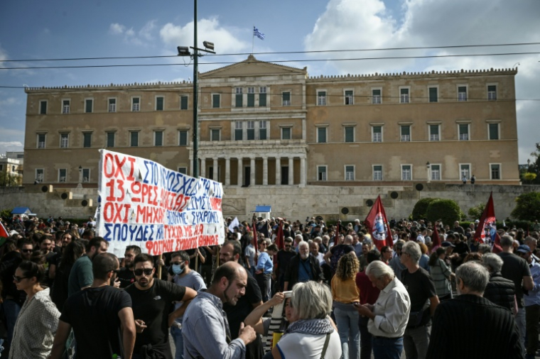 Des manifestants sont regroupés devant le Parlement grec lors d'une grève contre une réforme permettant des journées de travail de 13 heures, le 14 octobre 2025 à Athènes ( AFP / Aris MESSINIS )