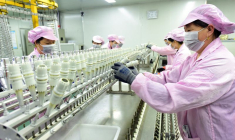 Workers work on a production line manufacturing bottle caps for export at a factory of a packaging company in Lianyungang