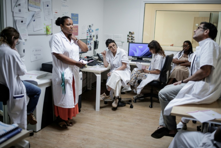 Réunion des soignants au Centre renforcé d'urgences psychiatriques, au sein de l'hôpital Delafontaine de Saint-Denis en Seine-Saint-Denis, avec le dr Fayçal Mouaffak, chef de secteur, assis à droite, et la dr Nadia Cheffi, cheffe du Crup, assise au centre, le 17 juin 2026  ( AFP / Simon WOHLFAHRT )